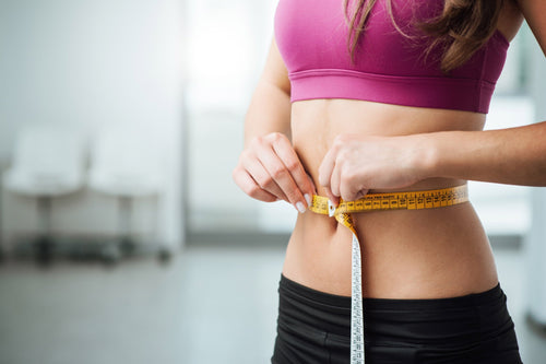 girl measuring her waistline