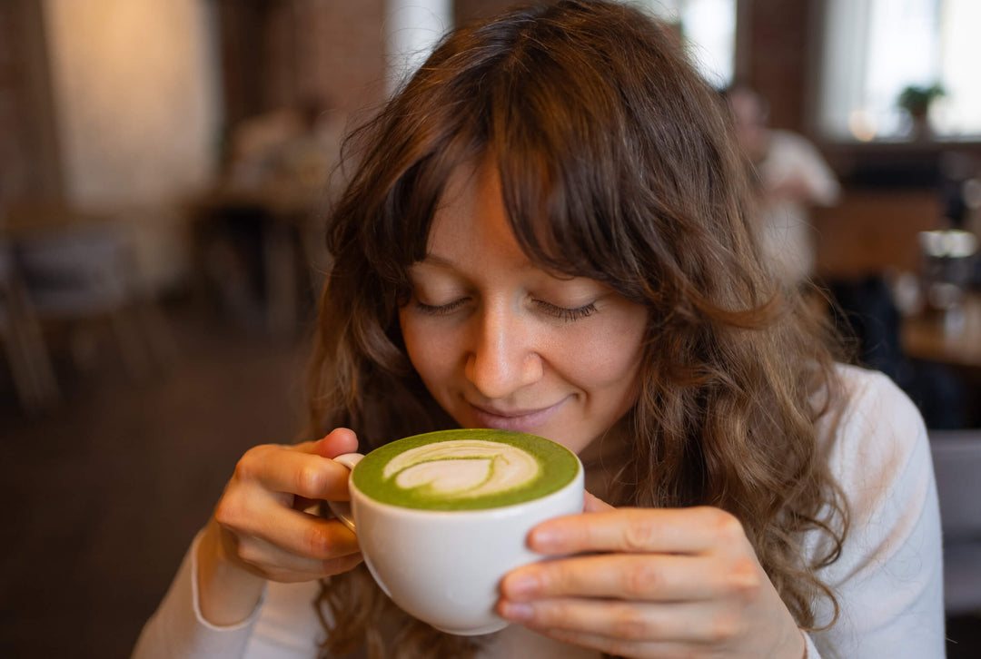 woman drinking matcha in a cup